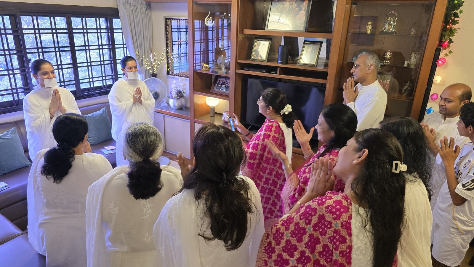 The mumukshus blessing a family at their home